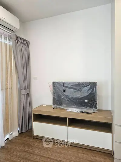 Modern living room with sleek TV stand and air conditioning, perfect for cozy relaxation.