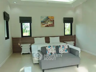Spacious bedroom with modern decor and cozy seating area