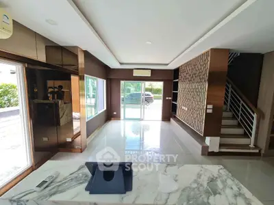 Spacious modern living room with marble countertop and large windows offering natural light.
