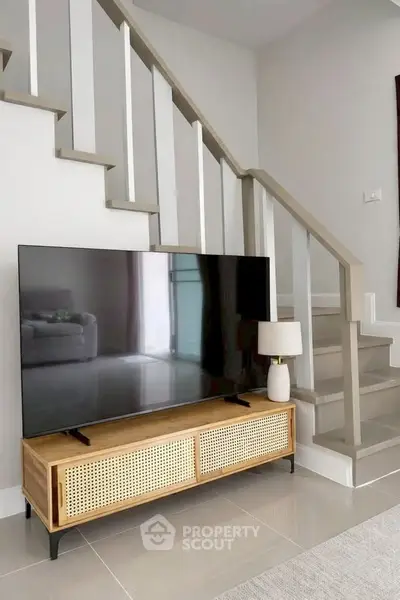 Modern living room with stylish TV stand and staircase