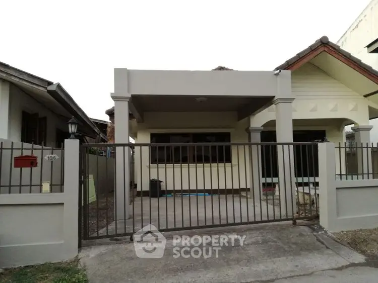 Charming single-story house with gated entrance and driveway.