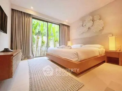 Luxurious bedroom with modern decor and large window overlooking lush greenery.