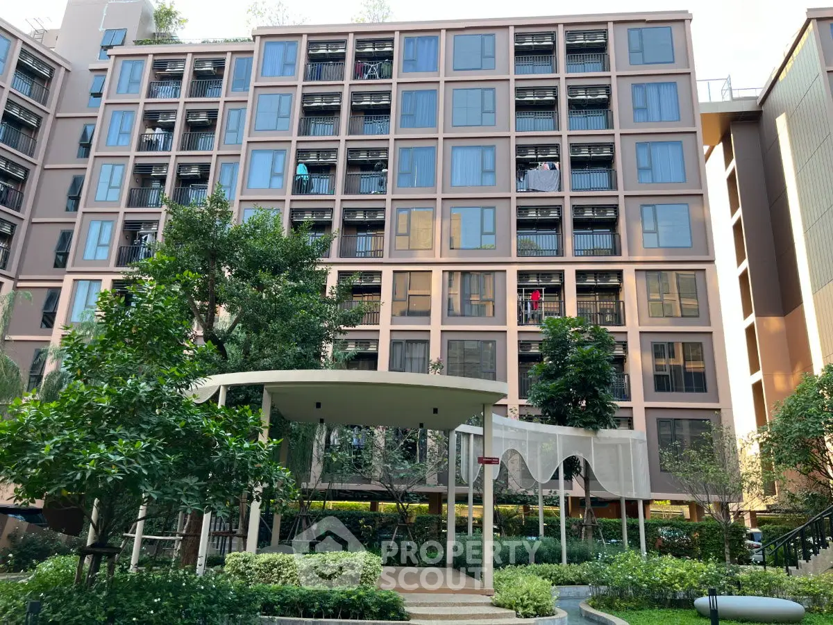 Modern residential building with lush garden and entrance canopy