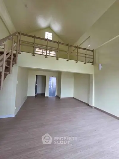 Spacious loft-style living room with high ceilings and wooden flooring