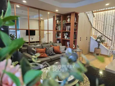 Stylish living room with modern decor and open layout, featuring cozy seating and elegant shelving.