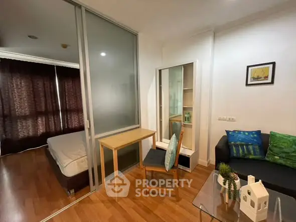 Modern studio apartment with sliding glass partition, cozy living area, and stylish decor.