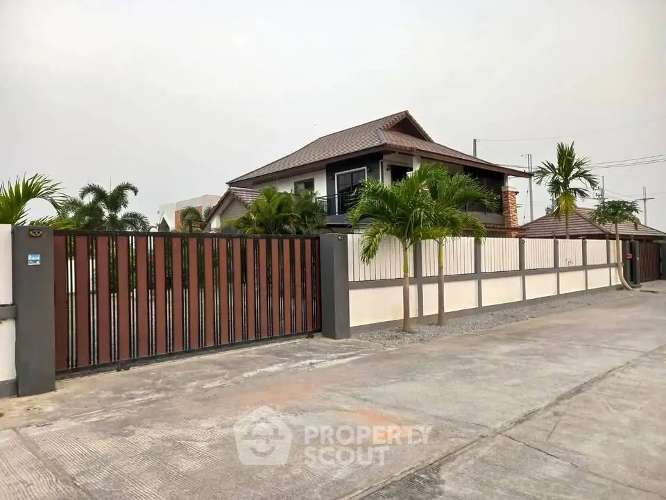 Stunning modern house with gated entrance and lush palm trees, offering privacy and elegance in a serene neighborhood.
