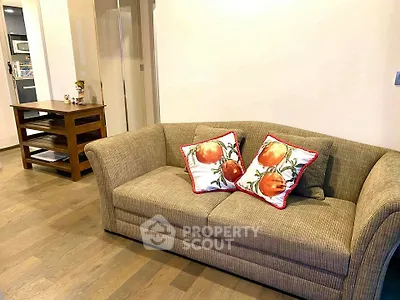 Cozy living room with stylish sofa and decorative pillows, perfect for relaxation.