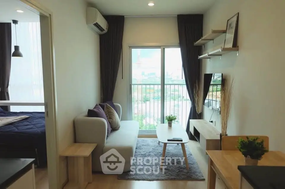 Modern living room with cozy sofa, TV, and balcony view in stylish apartment.