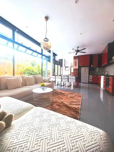 Spacious modern living room with open kitchen, large windows, and stylish decor in a luxurious home.
