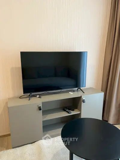 Modern living room with sleek TV setup on stylish cabinet, perfect for entertainment.