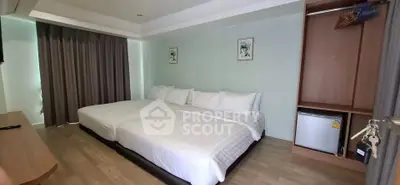 Spacious bedroom with twin beds and modern decor, ideal for comfort and relaxation.