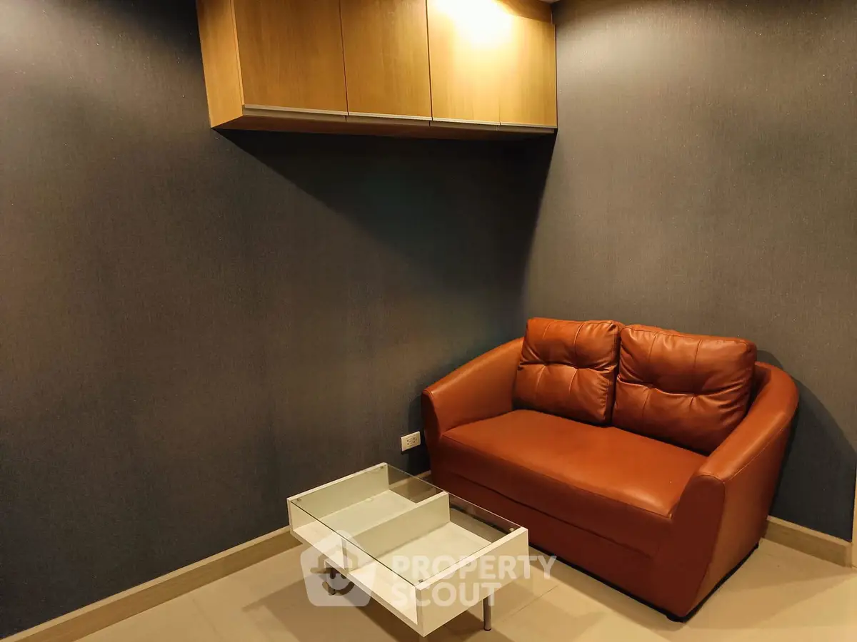 Cozy living room with modern leather sofa and sleek glass coffee table, perfect for relaxation.