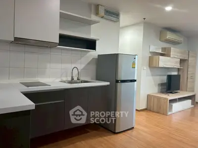 Modern kitchen with sleek cabinetry and stainless steel appliances in a stylish apartment.