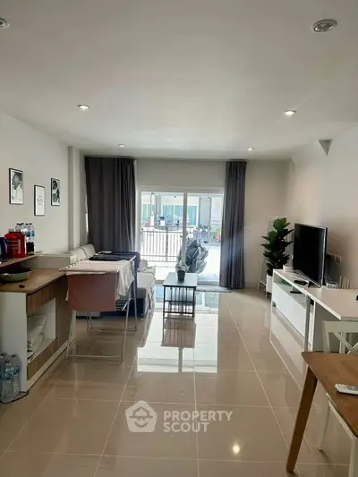 Modern living room with sleek design and balcony view, featuring stylish furniture and ample natural light.