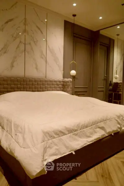 Luxurious bedroom with elegant decor and modern lighting, featuring a plush bed and stylish wall design.