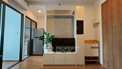 Modern living room with sleek TV unit and open kitchen view