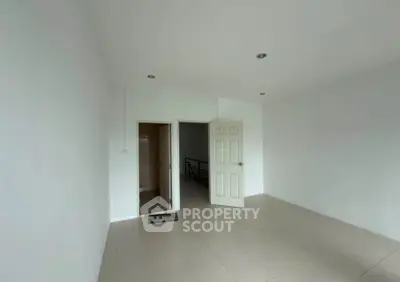 Spacious unfurnished room with tiled flooring and open door leading to hallway.