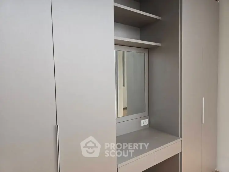 Modern built-in wardrobe with mirror and shelves in a stylish interior.