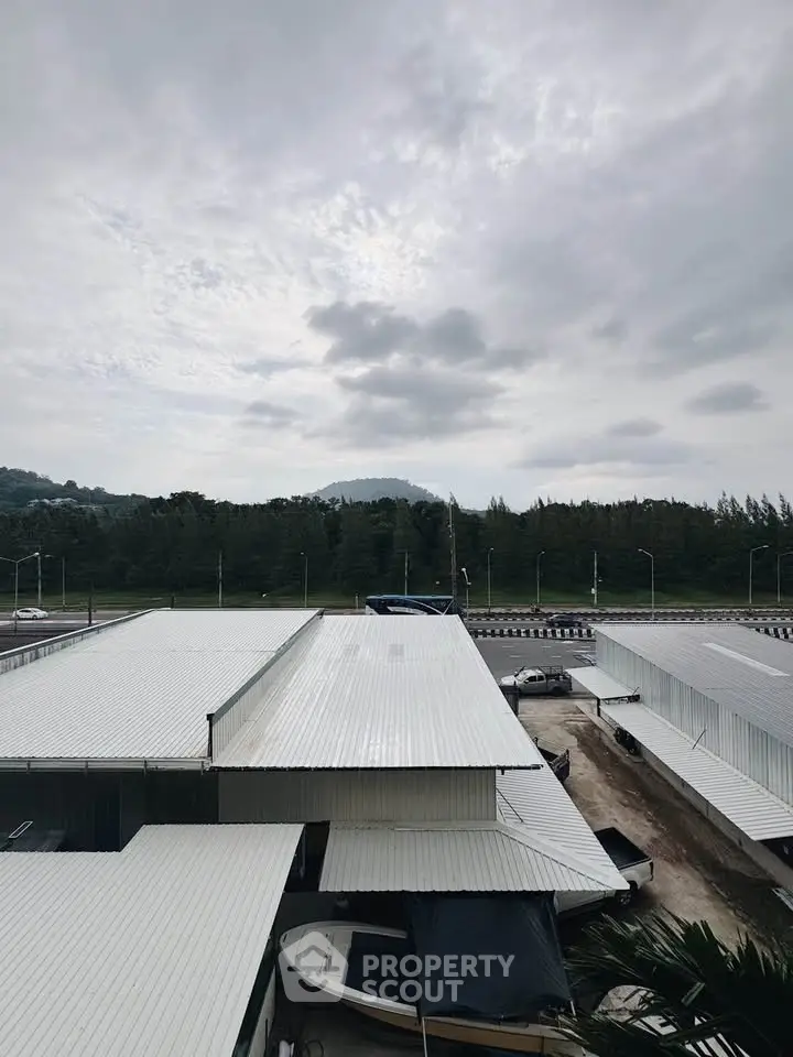 Industrial warehouse with metal roofing and scenic mountain backdrop