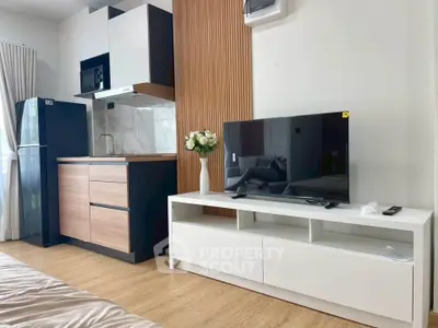 Modern studio apartment with sleek kitchen and cozy living area, featuring stylish wood accents and natural light.