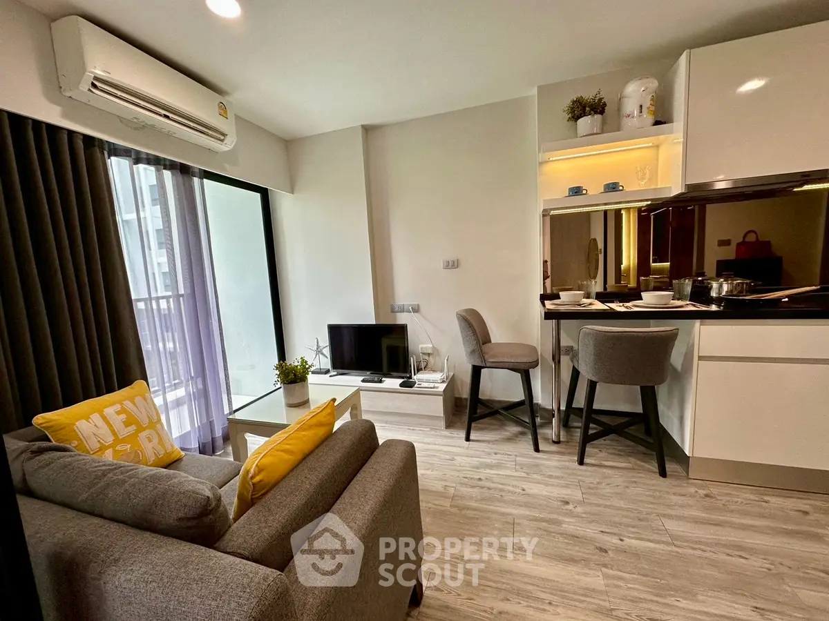 Modern living room with open kitchen and stylish decor in a cozy apartment.