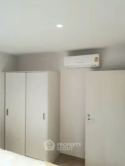 Modern bedroom with sleek wardrobe and air conditioning unit