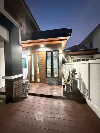 Charming modern home entrance with warm lighting and stylish wooden door, perfect for welcoming guests.