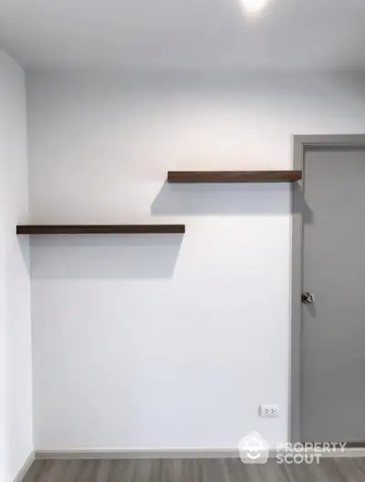 Minimalist room with floating shelves and modern door