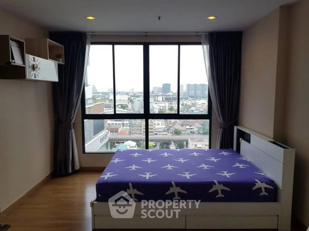 Modern bedroom with large window offering city view and stylish decor.