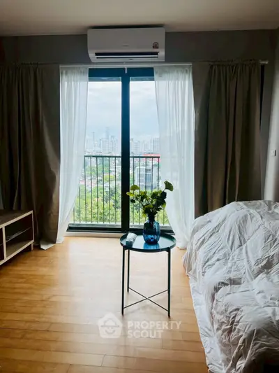 Bright bedroom with city view, featuring a cozy bed and stylish decor.