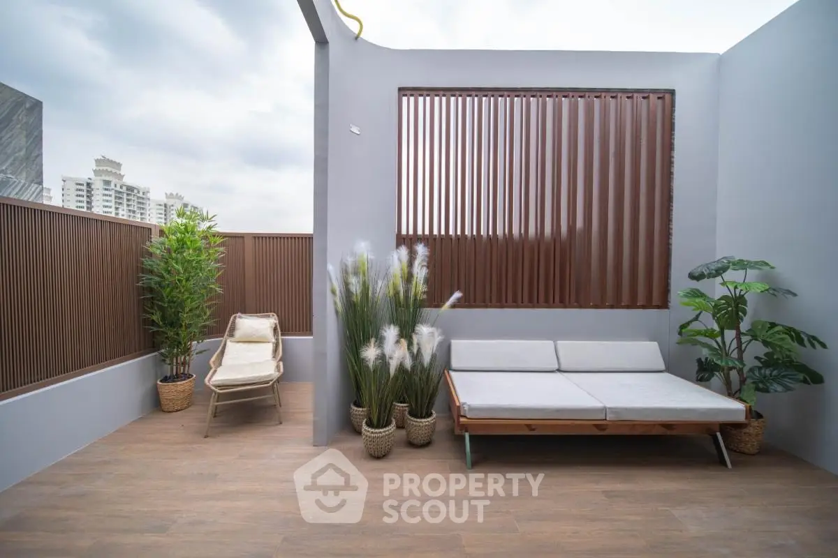 Stylish rooftop terrace with modern seating and lush greenery, perfect for relaxation and entertaining.