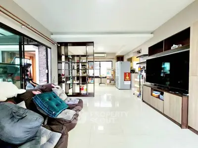 Spacious living room with modern decor and large TV, perfect for family gatherings.