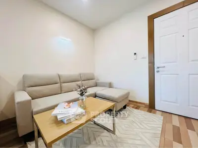 Cozy living room with modern beige sofa and stylish wooden coffee table.