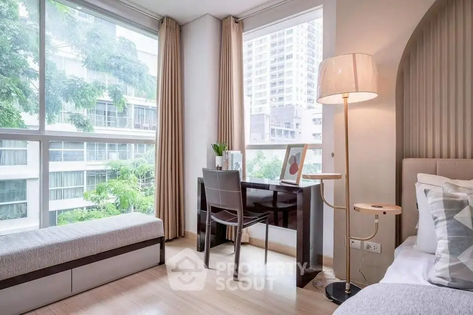 Bright modern bedroom with large windows and cozy workspace