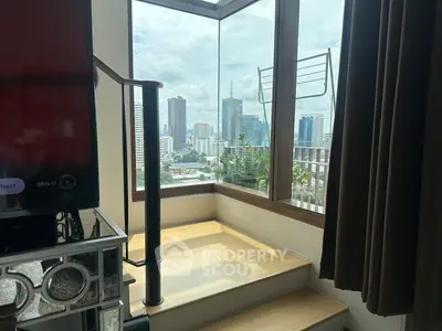 Stunning city view from modern apartment with floor-to-ceiling windows and cozy interior.