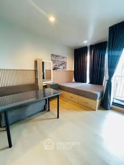 Modern studio apartment with cozy bed, stylish decor, and ample natural light.