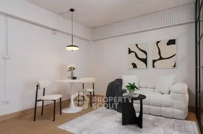 Modern living room with stylish furniture and abstract art, featuring a cozy white sofa and elegant dining area.