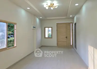 Spacious modern living room with natural light and elegant wooden door