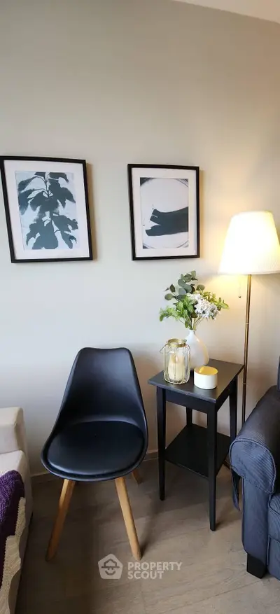 Stylish living room corner with modern chair, side table, and framed art, perfect for cozy relaxation.