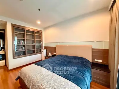 Spacious bedroom with modern design and cozy ambiance, featuring a large bed and built-in storage.