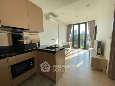 Modern apartment with open kitchen and bright living area overlooking cityscape.