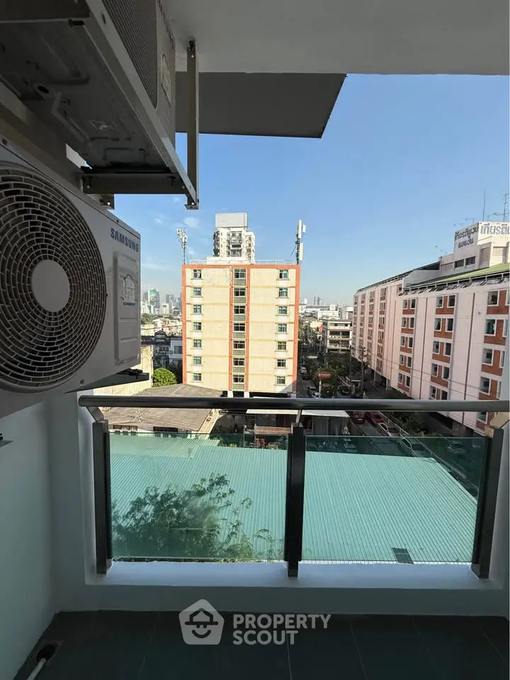 Stunning city view from a modern balcony with glass railing, perfect for urban living.