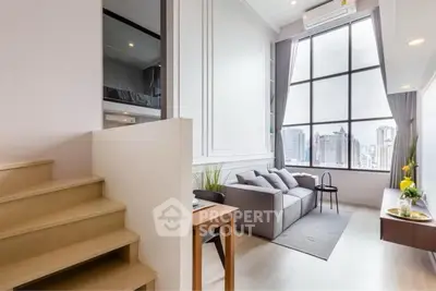 Modern living room with high ceiling and city view, featuring stylish furniture and large windows.
