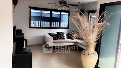 Cozy living room with modern decor and large vase, perfect for relaxation.