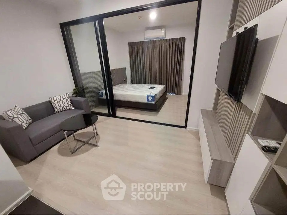 Modern apartment with cozy living room and bedroom, featuring sleek design and stylish furnishings.