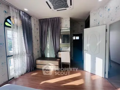 Charming bedroom with elegant decor and natural light, featuring a stylish vanity and hardwood floors.