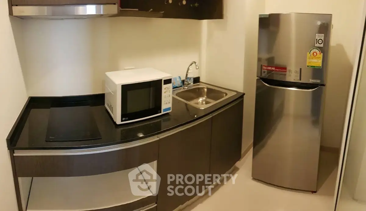 Modern compact kitchen with sleek appliances and stylish cabinetry