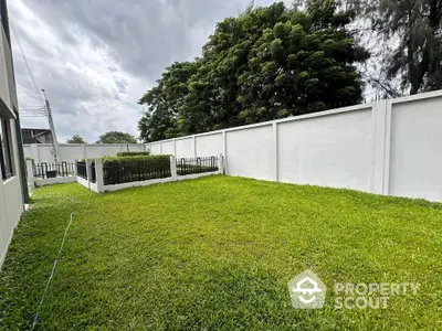 Spacious backyard with lush green lawn and privacy fence