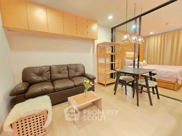 Modern living room with cozy seating and dining area in open layout apartment.